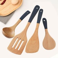 three wooden utensils are sitting on a table