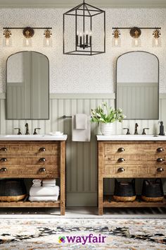 a bathroom with two sinks, mirrors and lights on the wall next to each other