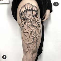 a man's leg with a jellyfish tattoo on it