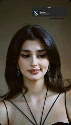 a woman with long dark hair wearing earrings