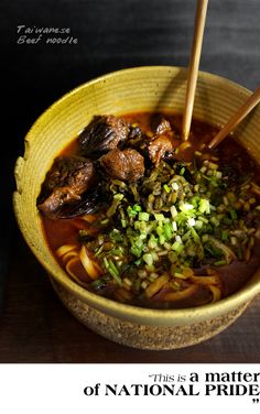 a bowl of food with chopsticks sticking out of the meat and vegetable in it