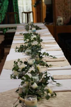 the long table is decorated with flowers and greenery