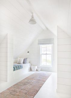 an attic bedroom with white walls and wood flooring is featured in the magazine amberinteritors