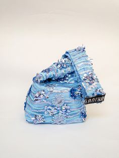 a blue bag with flowers on it sitting on a white surface