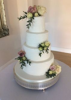 a three tiered white cake with flowers on it