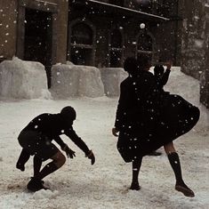 two people are playing in the snow outside