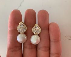 Large Pearl CZ Studs, Bridal Earrings, Bridesmaid Gift, Wedding Jewelry, Round 12MM Cream Pearl with Cubic Zirconia Pave and Baguette Post Earrings  HANDMADE-BAGUETTE PEARL STUD EARRINGS   ⁙ Materials: Sterling Silver, 18K Gold over Silver, Cubic Zirconia, Fresh Water Pearl ⁙ Available colors: Gold, Rose Gold and Silver ⁙ Earrings Measurements: 25MM in length by 12MM in width   ⁙ PROCESSING TIMES: 1-5 business days, does not include holidays or weekends ⁙  All items are packaged in plastic zip bags, please note due to hygienic reasons Earrings are final sale and cannot be exchanged or returned. Please refer to the actual dimensions as we have enlarged the pictures so that you can see the details.  OUR STORE POLICIES https://www.etsy.com/shop/ynyjewelry?ref=seller-platform-mcnav FOLLOW US I White Oval Earrings For Wedding, Round Bridal Earrings With Diamond Accents, Oval Cubic Zirconia Wedding Earrings, Pear-shaped Diamond Accented Bridal Earrings, Pear-shaped Bridal Earrings With Diamond Accents, White Hand Set Pearl Earrings For Wedding, White Hand-set Pearl Earrings For Wedding, Hand-set White Pearl Earrings For Wedding, Hand-set Oval Earrings For Wedding