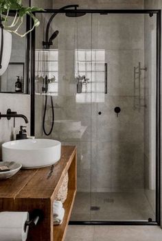 a bathroom with two sinks and a shower stall in it's corner, next to a wooden counter