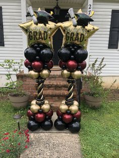 two large balloons with graduation decorations on them in front of a house