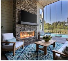 an outdoor living room with fireplace and seating area