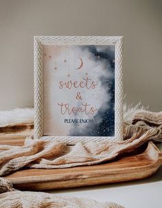 a wooden tray with a sign that says sweets and treats please enjoy on it next to some blankets