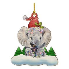 an elephant with a santa hat on its head is sitting in the snow, surrounded by christmas trees