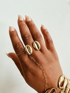 A beautiful brass double cowrie shell with a lightly textured adjustable ring band. The cowrie shell represents Goddess protection, as well as symbolizes the power of destiny and prosperity. It is perfect worn alone or with a few of our stack rings.DETAILS:Available in brass or gold plated brass Adjustable Ring Band Ships with sample polishing cloth Packaged for gift giving *Sold individually, not a set. Cowrie Shell Jewelry, Beautiful Baubles, African Dolls, Stack Rings, African Masks, Shell Jewelry, Cowrie Shell, Mud Cloth, Artistic Jewelry