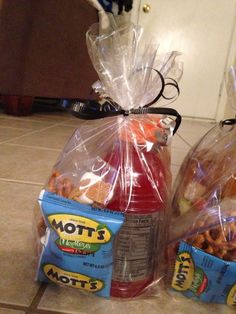 two plastic bags filled with food sitting on the floor