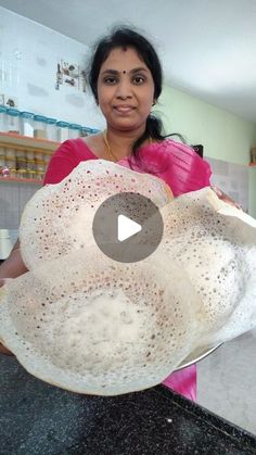 a woman is holding a large piece of bread