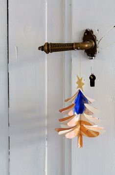 a wooden christmas tree hanging from a door handle