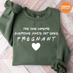 a green sweatshirt with the words, the one where everyone finds out she's pregnant