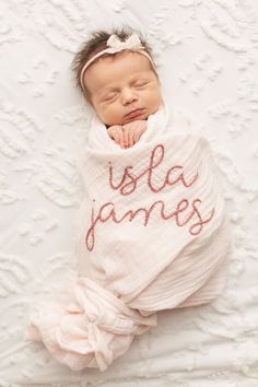 a baby wrapped in a blanket with the word usla james written on it