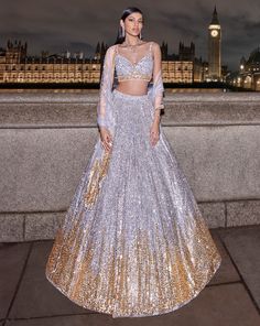 This lehenga set features silver and gold sequins and bead embroidery in a linear pattern. The strappy blouse has crystal droplets at the waist. It is paired with a matching net dupatta.From Seema Gujral's For the love of London collection. DELIVERY TIMEPlease allow 8-12 weeks for your outfit to arrive. FABRIC DETAILSNet Professional cleaning only. Elegant Silver Lehenga With Sequins, Designer Silver Lehenga With Sequins, Luxury Silver Sequined Lehenga, Festive Silver Embellished Lehenga, Silver Embellished Semi-stitched Lehenga, Sequin Lehenga, Linear Pattern, Gold Sequin, Gold Sequins