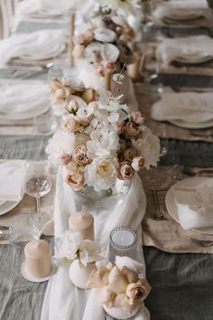 the table is set with white and pink flowers