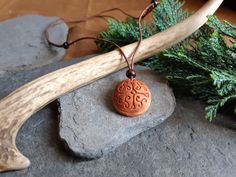 This pendant is a unique piece made by hand carving an avocado pit with a celtic pattern. As the avocado pit dries it shrinks and hardens, becoming very similar to wood. When I complete an avocado seed pendant I always apply a few coats of natural oils, such as linseed oil or tung oil, in this way the seed becomes more resistant and takes on a more intense and slightly more shiny colour.  The thread is made of genuine leather and its length is adjustable thanks to the sliding knots. The maximum Natural Carved Nature-inspired Necklace, Nature-inspired Carved Natural Necklace, Brown Carved Spiritual Jewelry, Brown Carved Amulet Necklaces, Spiritual Brown Carved Jewelry, Brown Carved Round Pendant Necklace, Nature-inspired Carved Natural Jewelry, Artisan Natural Color Carved Necklace, Natural Carved Necklaces As Gift