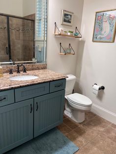 a bathroom with blue cabinets and a white toilet