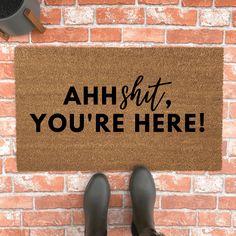 someone standing in front of a door mat that says ahh, you're here