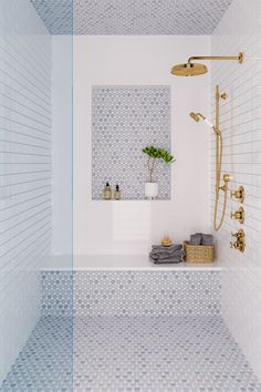 a bathroom with blue and white tiles on the walls, shower head, and bathtub