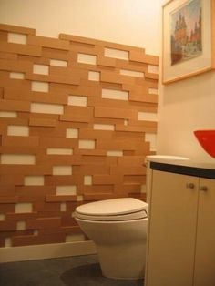 a white toilet sitting in a bathroom next to a sink and wooden paneled wall