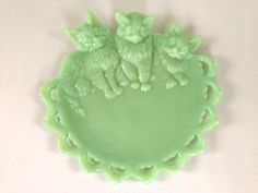 a green plate with two cats on it