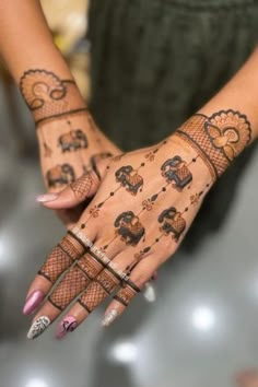 a woman's hands with henna tattoos on them