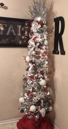 the christmas tree is decorated with silver and red ornaments