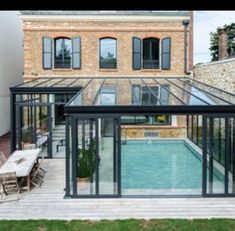 a house with a swimming pool in the middle of it's back yard and patio area