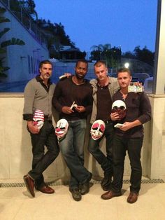 four men holding soccer balls in their hands and posing for a photo with the camera