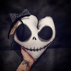 a person holding a white mask with black eyes and a skull on it's face