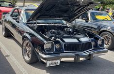 an old muscle car with its hood open