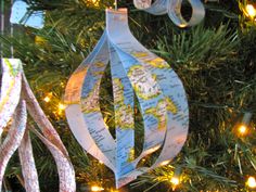 an ornament hanging from a christmas tree decorated with ribbon and lights is shown