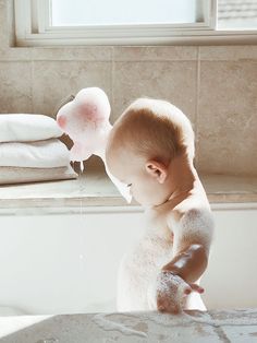 a baby in the bathtub playing with soap