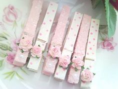 small pink flowers are placed on the edge of some matchesticks that have been decorated with polka dots