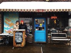 two people standing in front of a restaurant