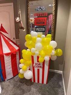 some balloons are in front of a circus tent and a stuffed animal hanging from the ceiling