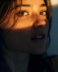 a close up of a woman's face with the sun shining on her