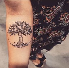 a woman's arm with a tree tattoo on it