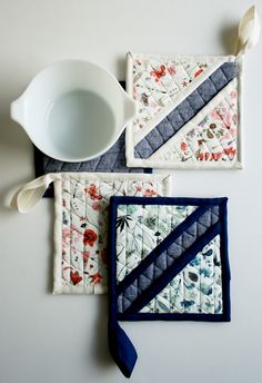 three pieces of quilted placemats on top of each other with a cup and spoon in the middle