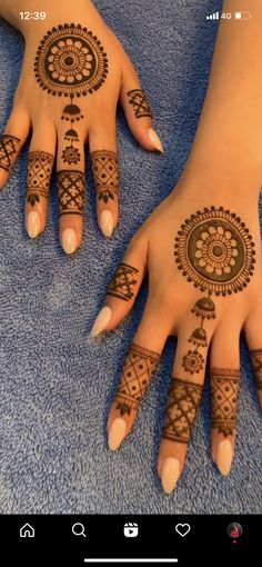 two hands with henna tattoos on them