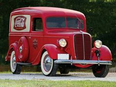 an old red truck is parked on the road