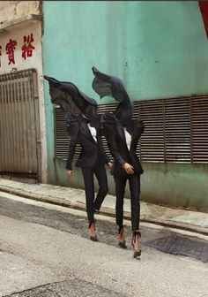 two women in black suits walking down the street