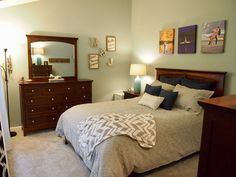 a bed room with a neatly made bed and dresser