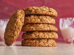 a stack of oatmeal cookies sitting on top of a table next to a glass of milk