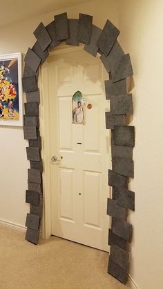 an arch made out of rocks is in the corner of a room with a door